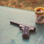 photo of handgun near mug