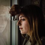 woman leaning on glass window