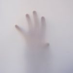 person s hand touching wall