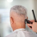 person using hair razor on man s hair