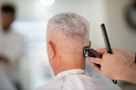 person using hair razor on man s hair